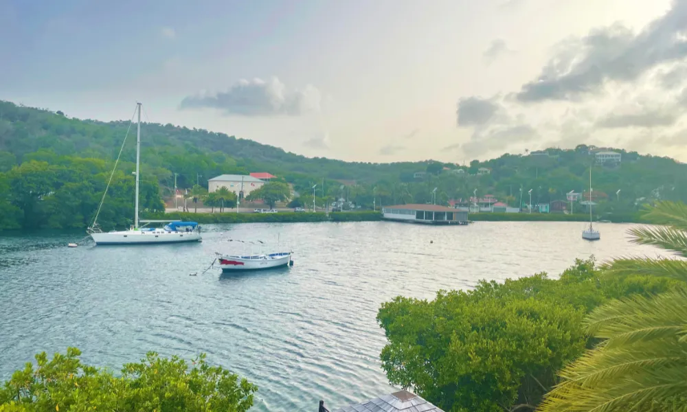 Boats in the water with green hills in the background 